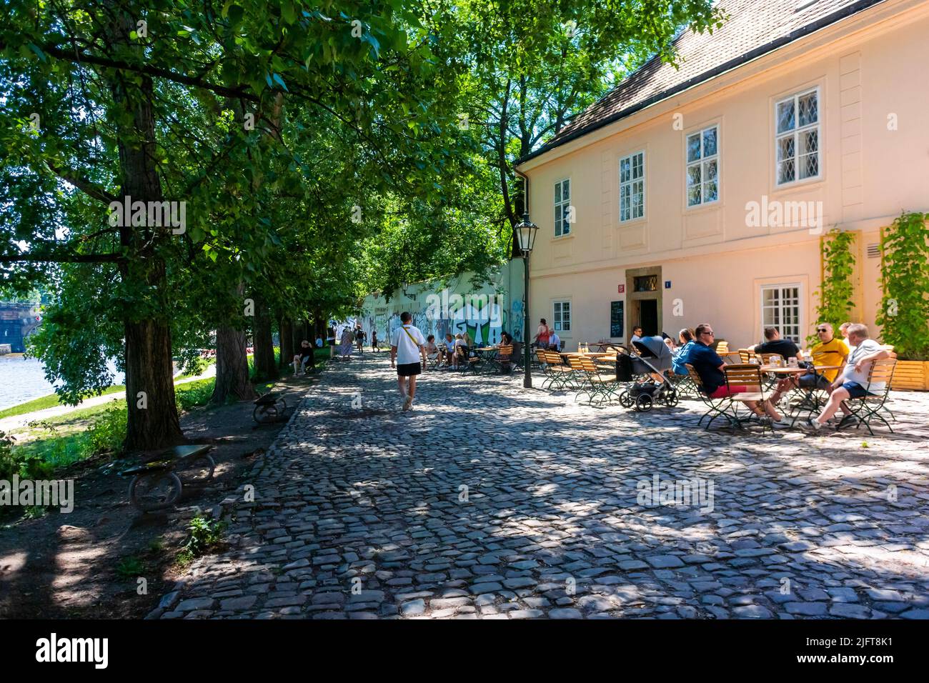 Prag, Tschechische Republik, Menschenmenge beim gemeinsamen Essen auf der Restaurantterrasse am Fluss Vlava, Sommer Stockfoto