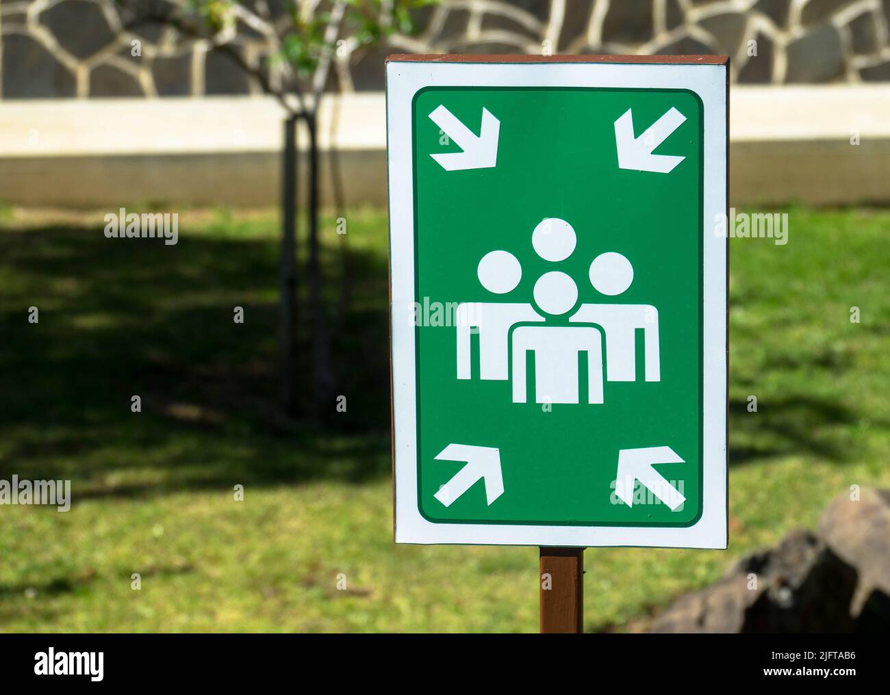 Grün ein weißes Montagepunkt-Schild. schild dient dazu, Personen zu sammeln und sie im Falle einer Evakuierung oder eines Notfalls an einen sicheren Ort zu bringen Stockfoto