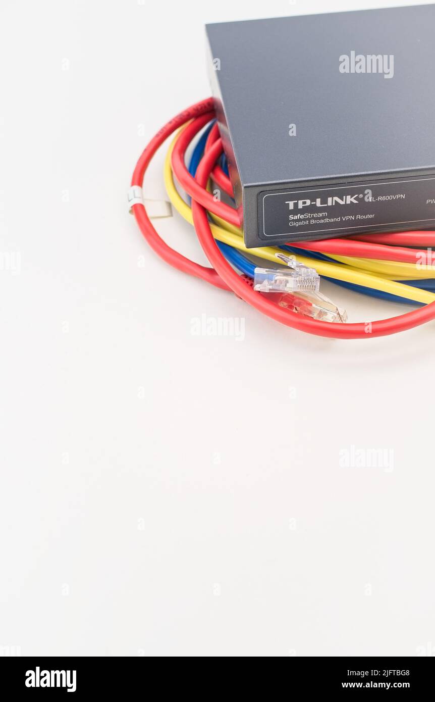 TP-LINK Gigabit Breitband-Netzwerk-Router mit Netzwerkkabeln auf einem weißen Schreibtisch Stockfoto