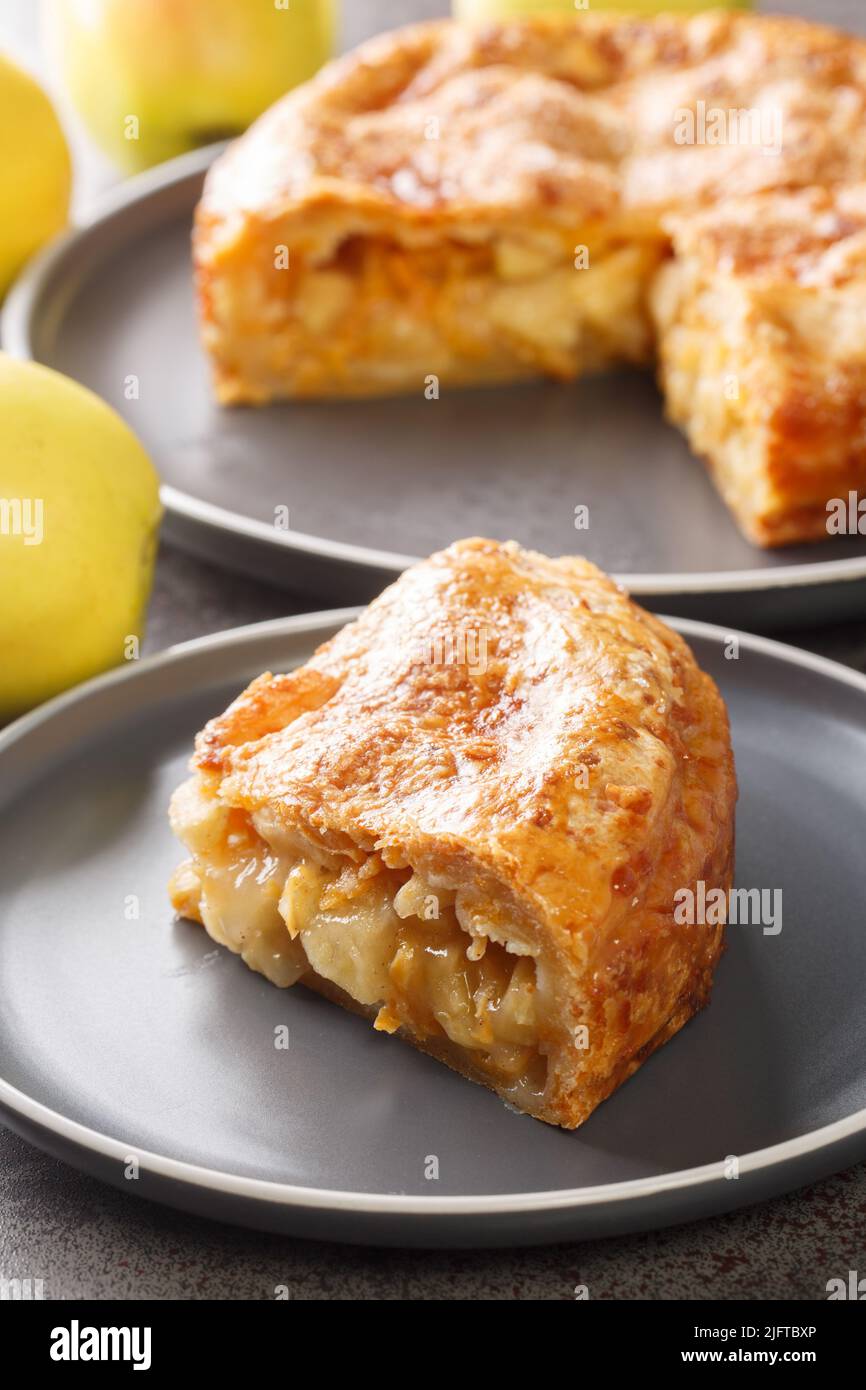 Stück Apfelkuchen mit Cheddar-Käse in der Nähe in der Platte auf dem Tisch. Vertikal Stockfoto