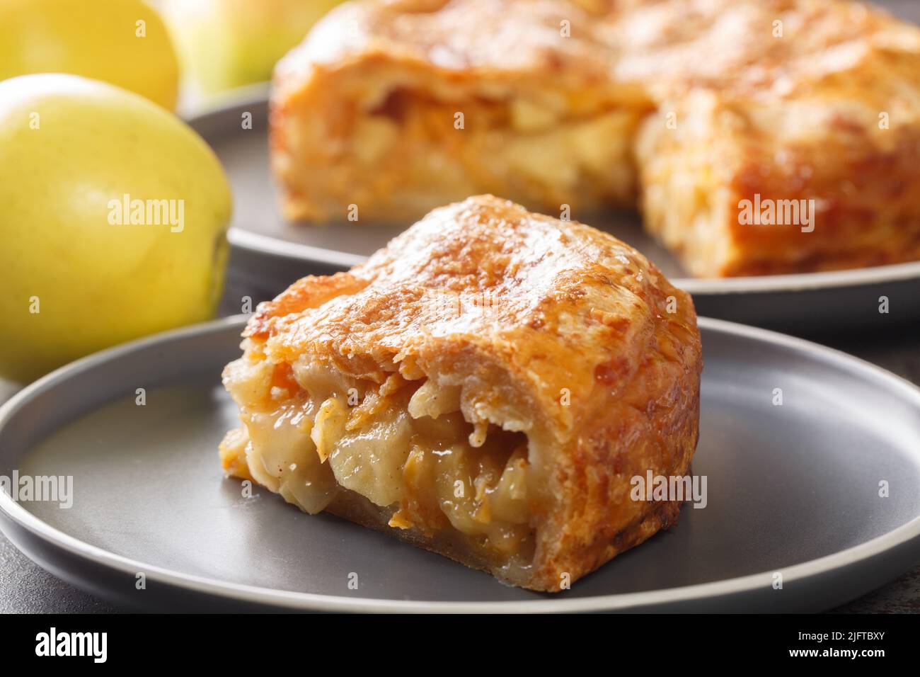 apfelkuchen mit Cheddar kombiniert eine buttrige Cheddar-Käsekruste und eine süße, gooey cinnamon-Apfel-Füllung aus der Nähe auf dem Teller auf dem Tisch. Horizontal Stockfoto