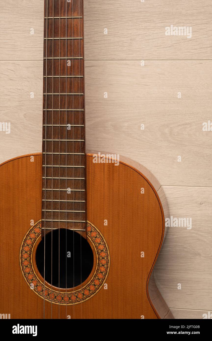 Klassischer Gitarrenkörper aus nächster Nähe, auf einem hellen Holzhintergrund mit Kopierraum. Stockfoto