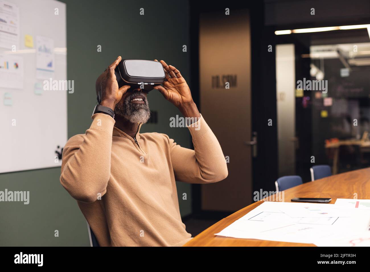 Reifer afroamerikanischer Geschäftsmann mit Virtual-Reality-Simulator im Büro Stockfoto