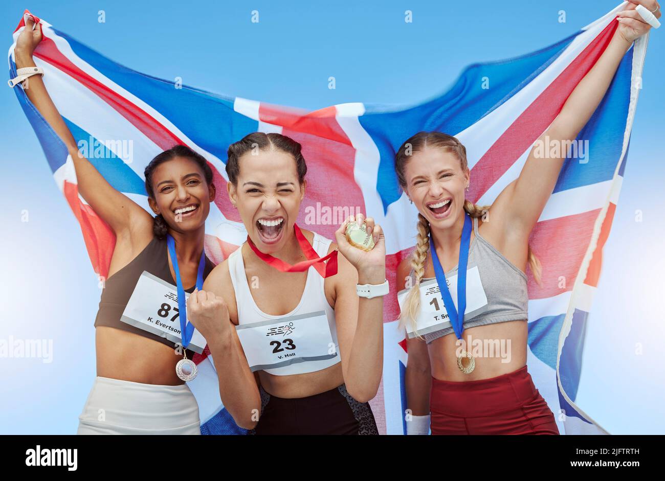 Britische Athleten, die ihre olympischen Goldmedaillengewinne feiern, winken mit der Flagge von Union Jack. Glückliche und stolze Meister des Vereinigten Königreichs. Gewinnen eines Stockfoto