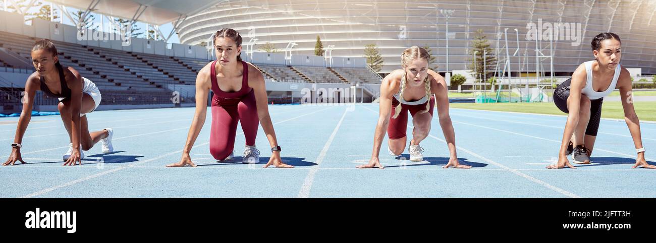 Gruppe von entschlossenen weiblichen Athleten in Startposition, um einen Sprint oder ein Laufrennen auf einer Sportstrecke in einem Stadion zu beginnen. Fokussierte und vielfältige Frauen Stockfoto