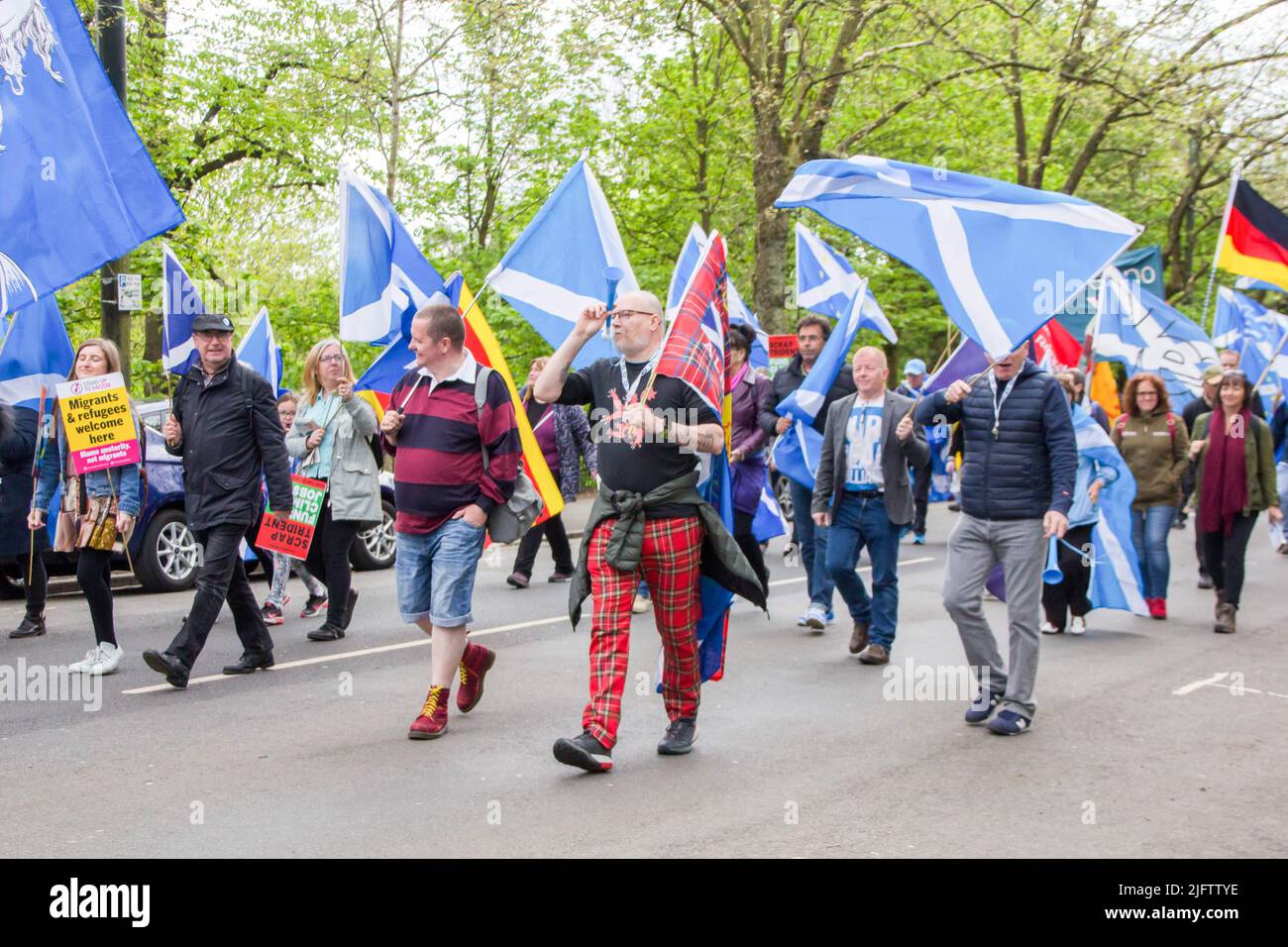 Schottische Menschen, die die Straße hinunter in Glasgow laufen, halten Flaggen für Indyref 2 Stockfoto