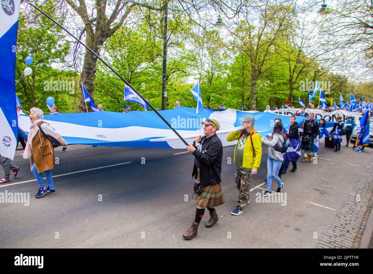 Die Menschen, die für das zweite Unabhängigkeitsreferendum marschieren, tragen eine große schottische Flagge Stockfoto
