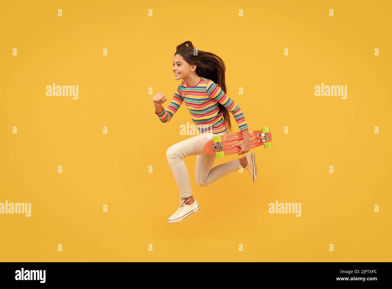 Glücklich energetische Kind Skateboarder springen mit Penny Board Skateboard, Kindheit Stockfoto