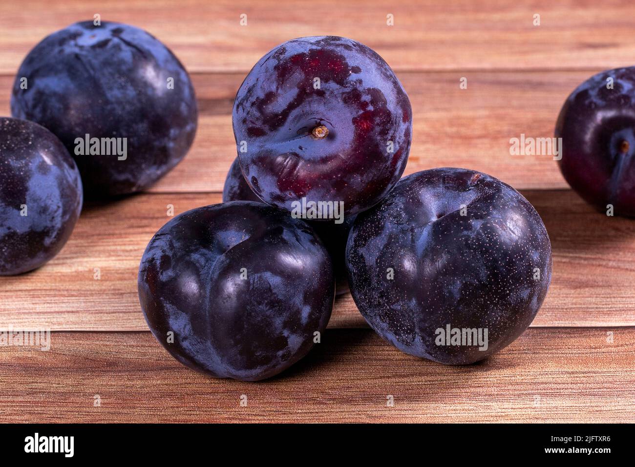 Schwarze Pflaume auf Holzhintergrund. Nahaufnahme Stockfoto