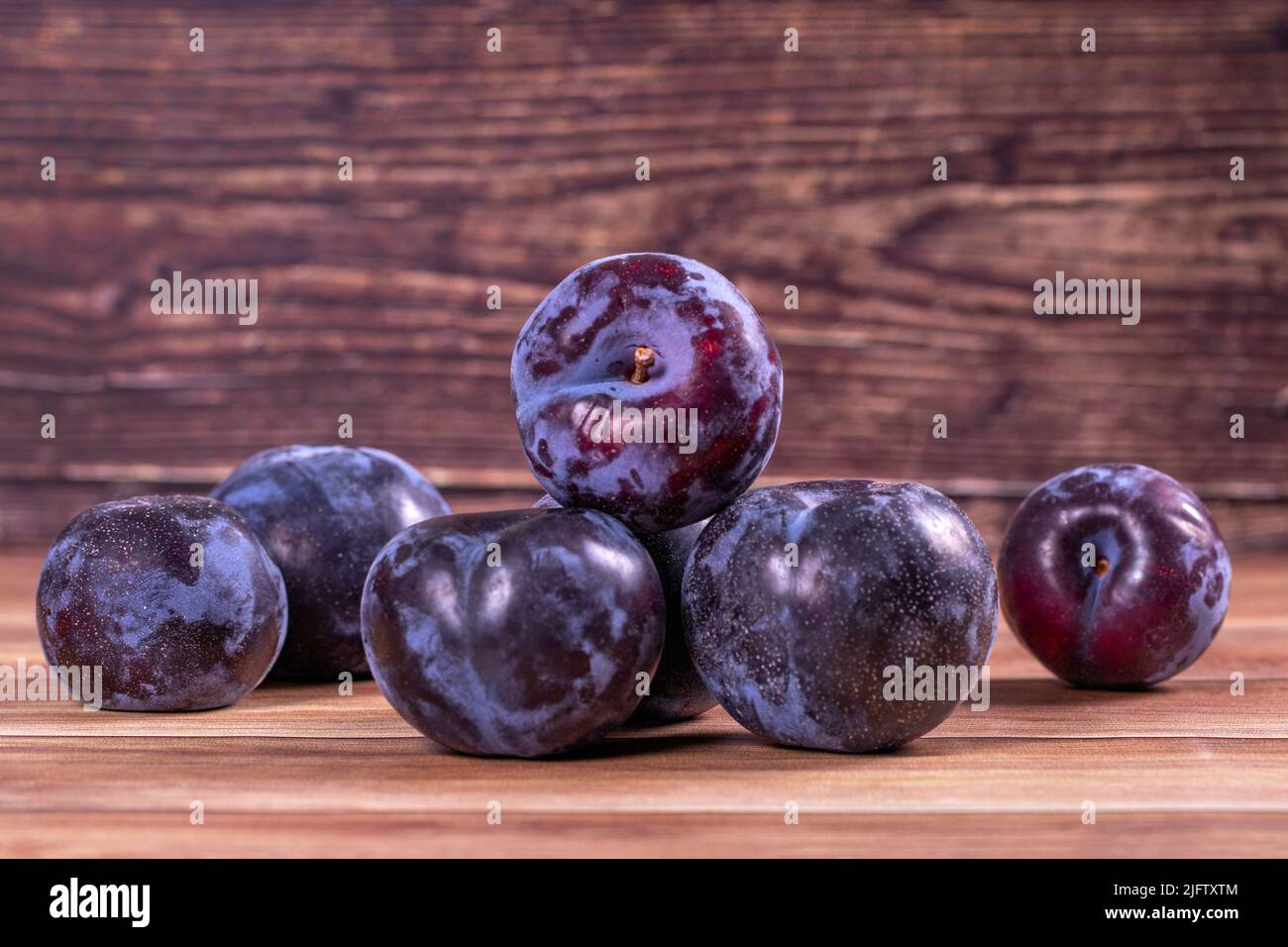 Schwarze Pflaume auf Holzhintergrund. Nahaufnahme Stockfoto