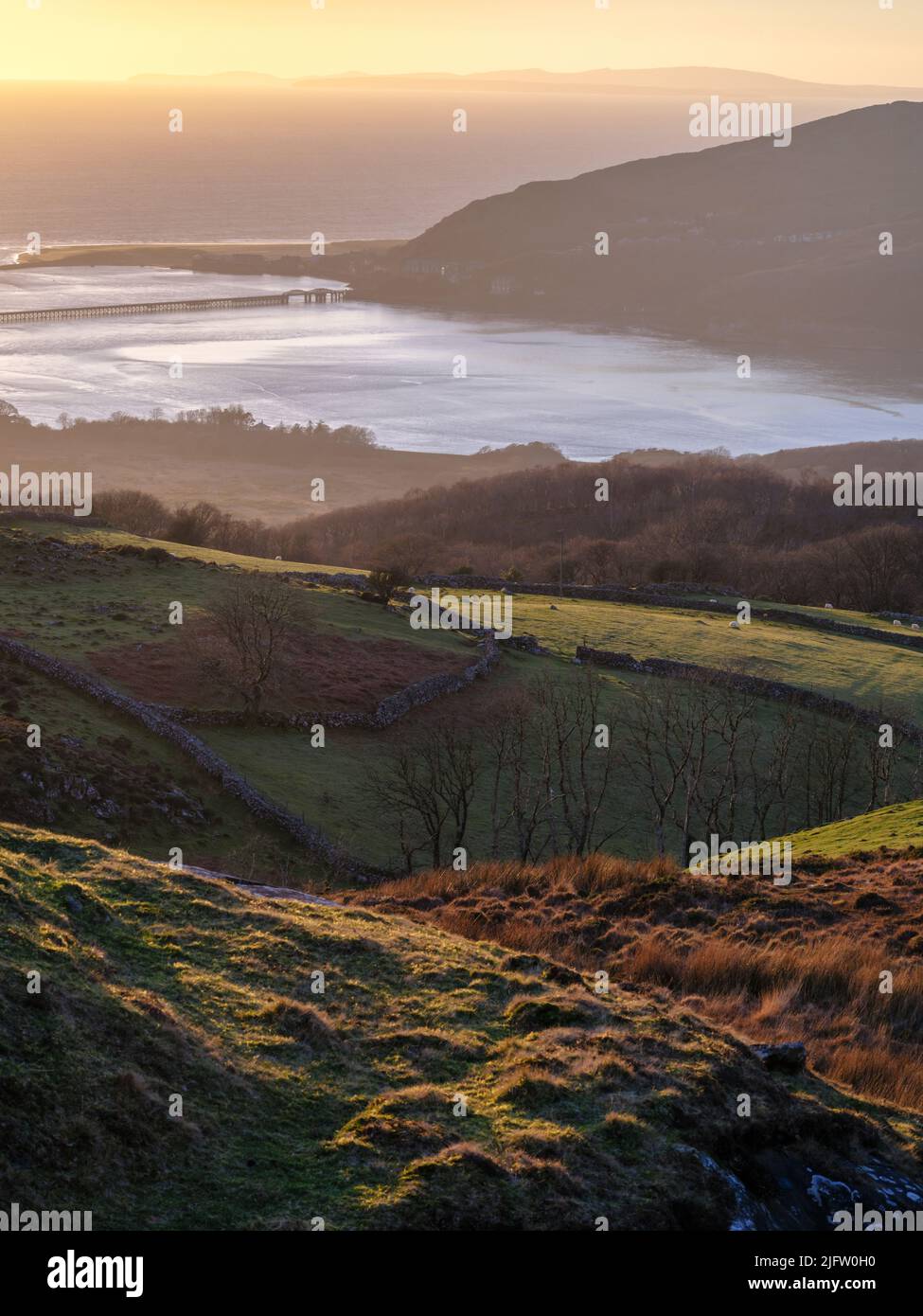 Blick über die walisische Landschaft in Richtung der Küstenstadt Barmouth bei Sonnenuntergang, Gwynedd, Nordwales Stockfoto