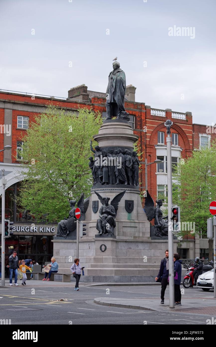 Vertikale Aufnahme des O'Connell Monument vom Bildhauer John Henry Foley in Dublin. Schwarze Statue auf hellgrauem Sockel mit Figuren von Engeln, Frauen und Männern. Stockfoto