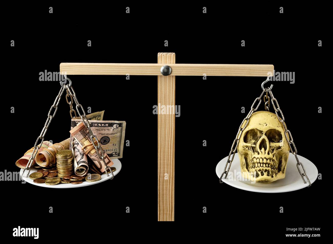 Schädel und Geld auf einem Two Pan Balance Stockfoto