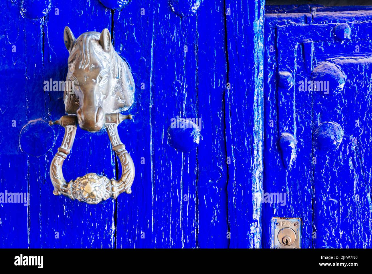 Knocker mit Pferdekopf. Indigo Tür mit Niete. Puerto Lápice, Ciudad Real, Castilla La Mancha, Spanien, Europa Stockfoto