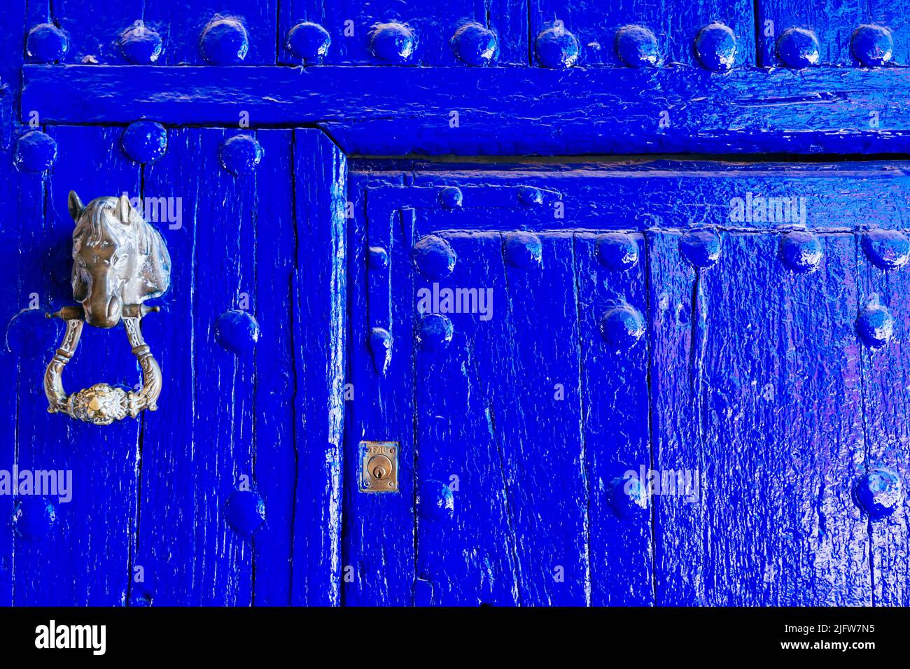 Knocker mit Pferdekopf. Indigo Tür mit Niete. Puerto Lápice, Ciudad Real, Castilla La Mancha, Spanien, Europa Stockfoto