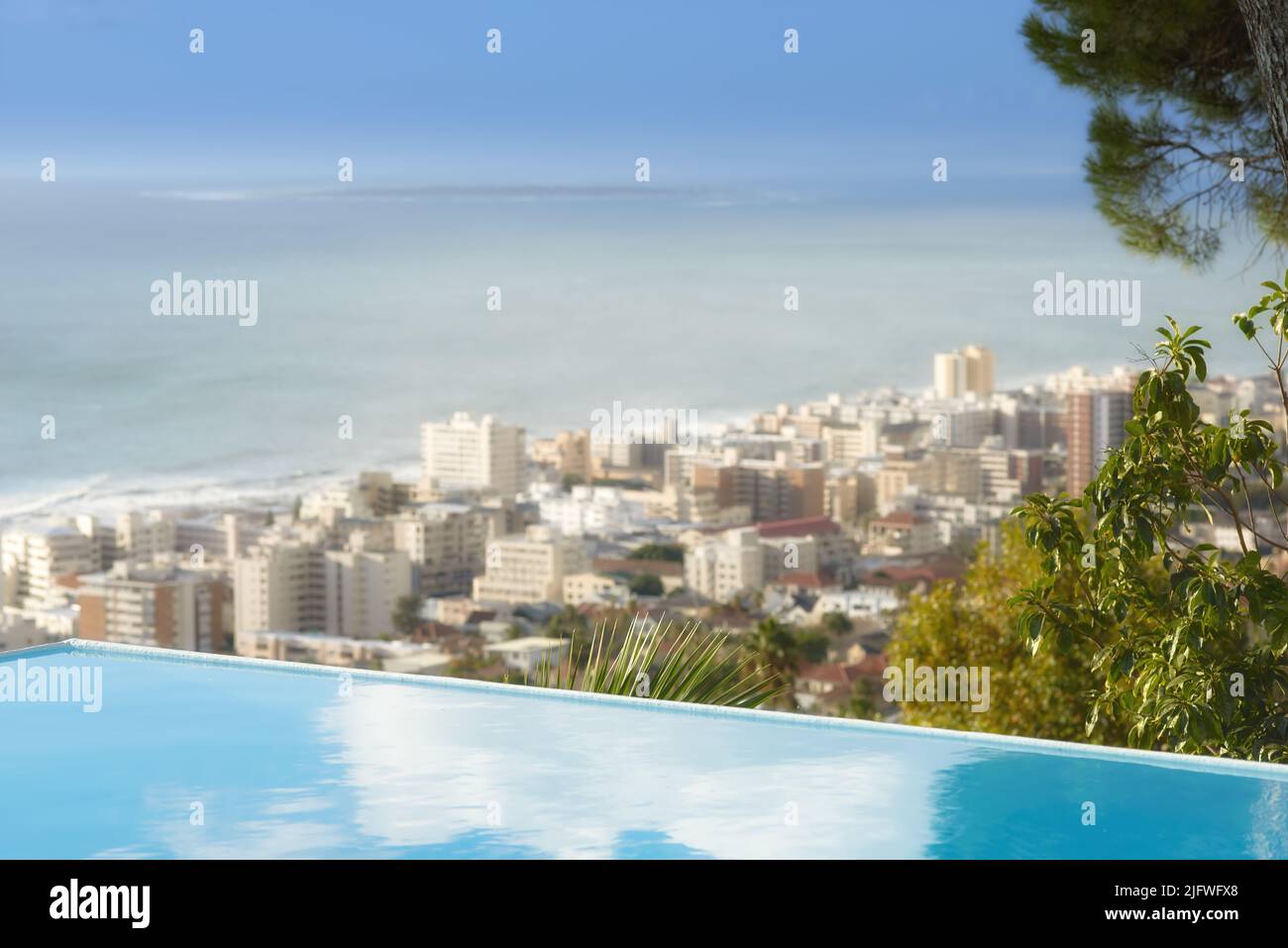 Malerischer Blick auf den unendlichen Swimmingpool mit Blick auf Sea Point in Kapstadt, Südafrika, mit Meereshintergrund. Luxuriöser Schreibtisch im Freien, Dachbereich Stockfoto