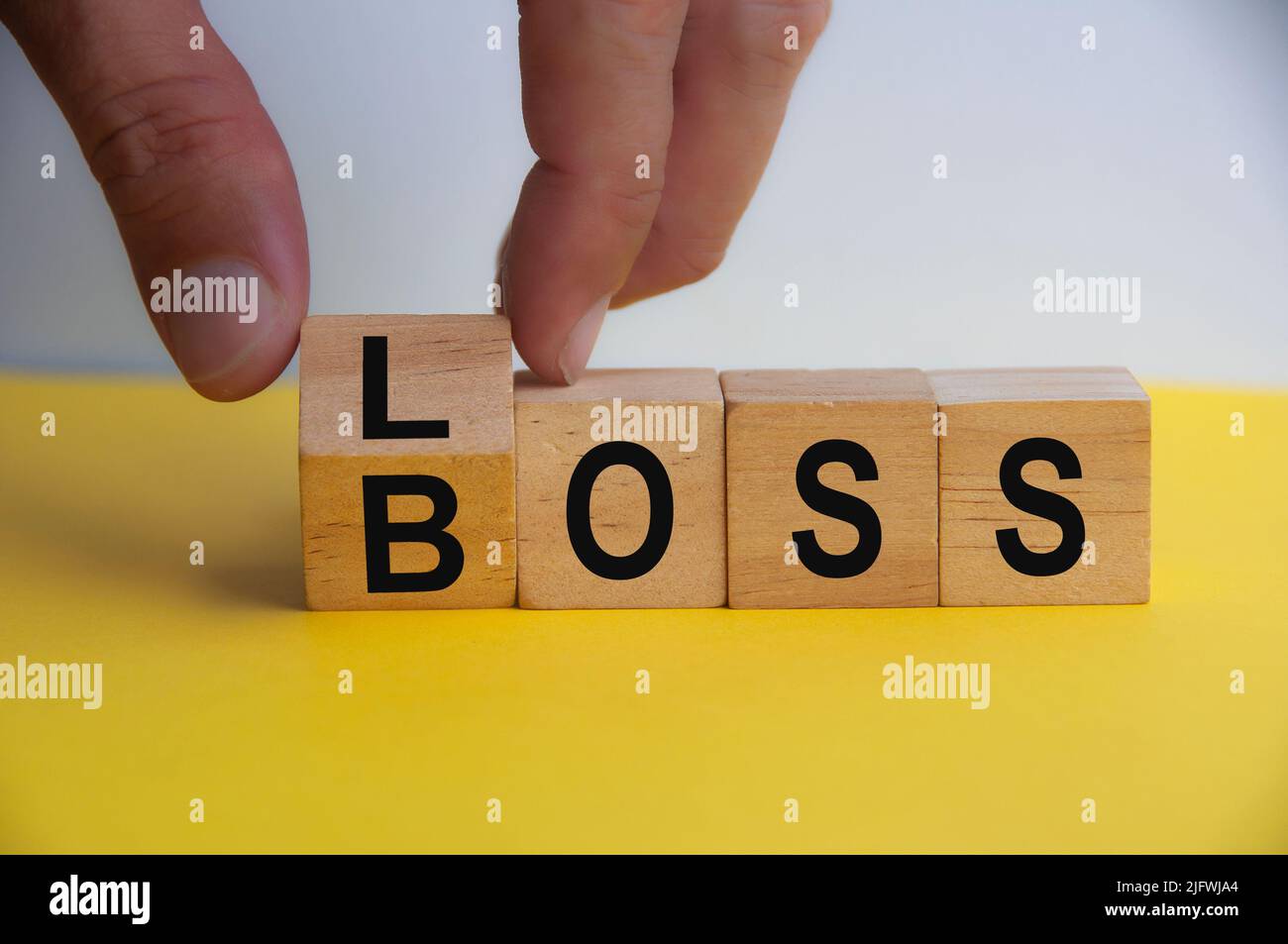 Hand drehen Holzwürfel zu VERLUST BOSS. Speicherplatz kopieren. Schlechtes Geschäftsführungskonzept. Stockfoto