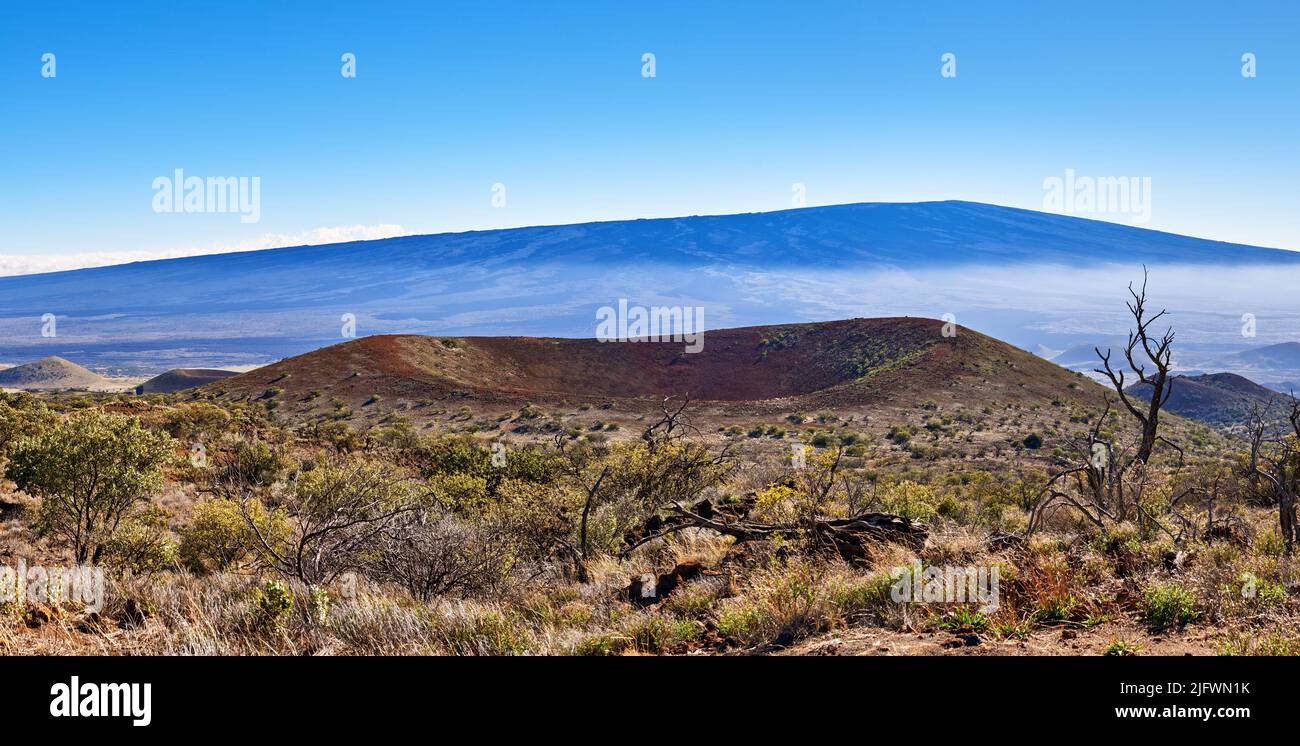 Landschaft aus trockenem Land und blauem Himmel mit Kopierraum. Ein schlafender Vulkan in einem offenen, nicht kultivierten Ort. Naturlandschaft mit buschiger Vegetation auf den Bergen Stockfoto