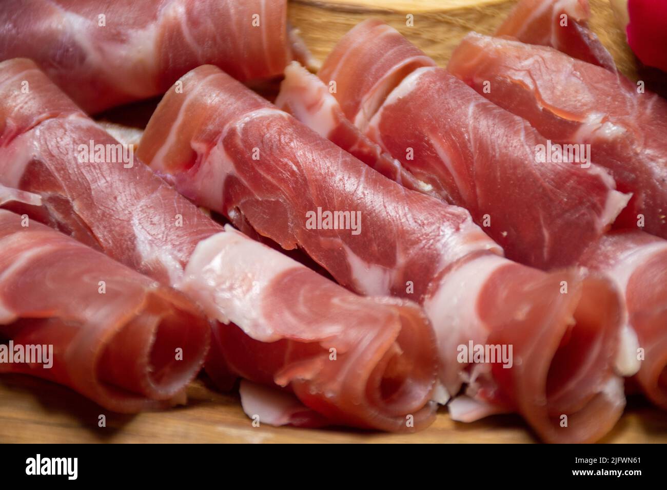 Schinken, in Scheiben geschnittenes Fleisch auf einem Holztablett Stockfoto