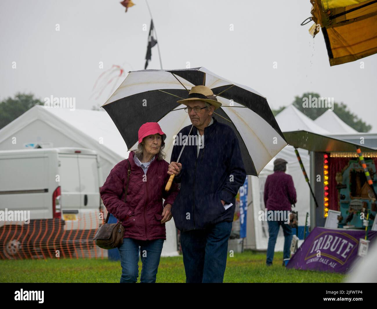 Couple in the Rain bei der Launceston Steam & Vintage Rally, Cornwall, Großbritannien Stockfoto