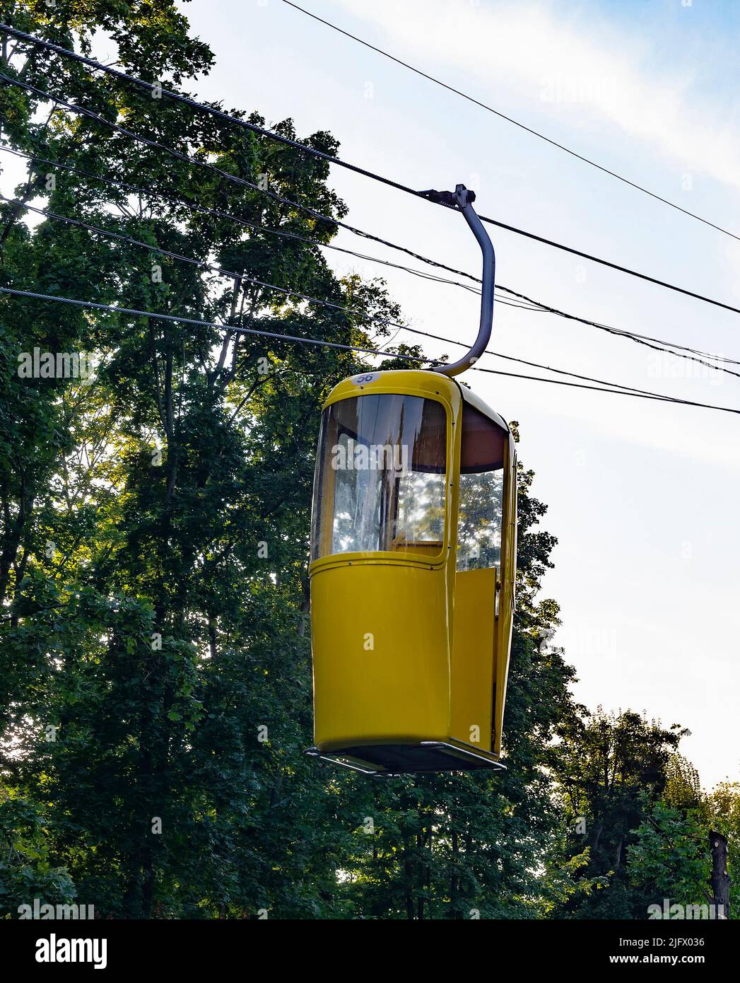 Neue farbenfrohe Seilbahn über den Park bei Sonnenuntergang im Sommer, Charkiw, Ukraine Stockfoto