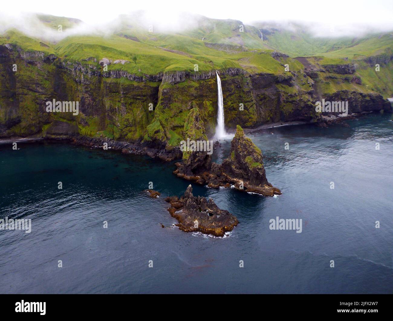 Wasserfall an der Nordküste der Insel Tanaga, in der Nähe des Takawangha-Vulkans auf den Aleuten. Tanaga Island ist eine Insel im westlichen Teil der Andreanof Islands, im südwestlichen Teil der Aleutischen Inseln, Alaska. Die Insel hat eine Landfläche von 204 Quadratmeilen (528 Quadratkilometer) und ist damit die 33. größte ozeanische Insel in den Vereinigten Staaten. Der höchste Punkt ist der Vulkan Mount Tanaga. Kredit: M.Coombs, USGS. Stockfoto