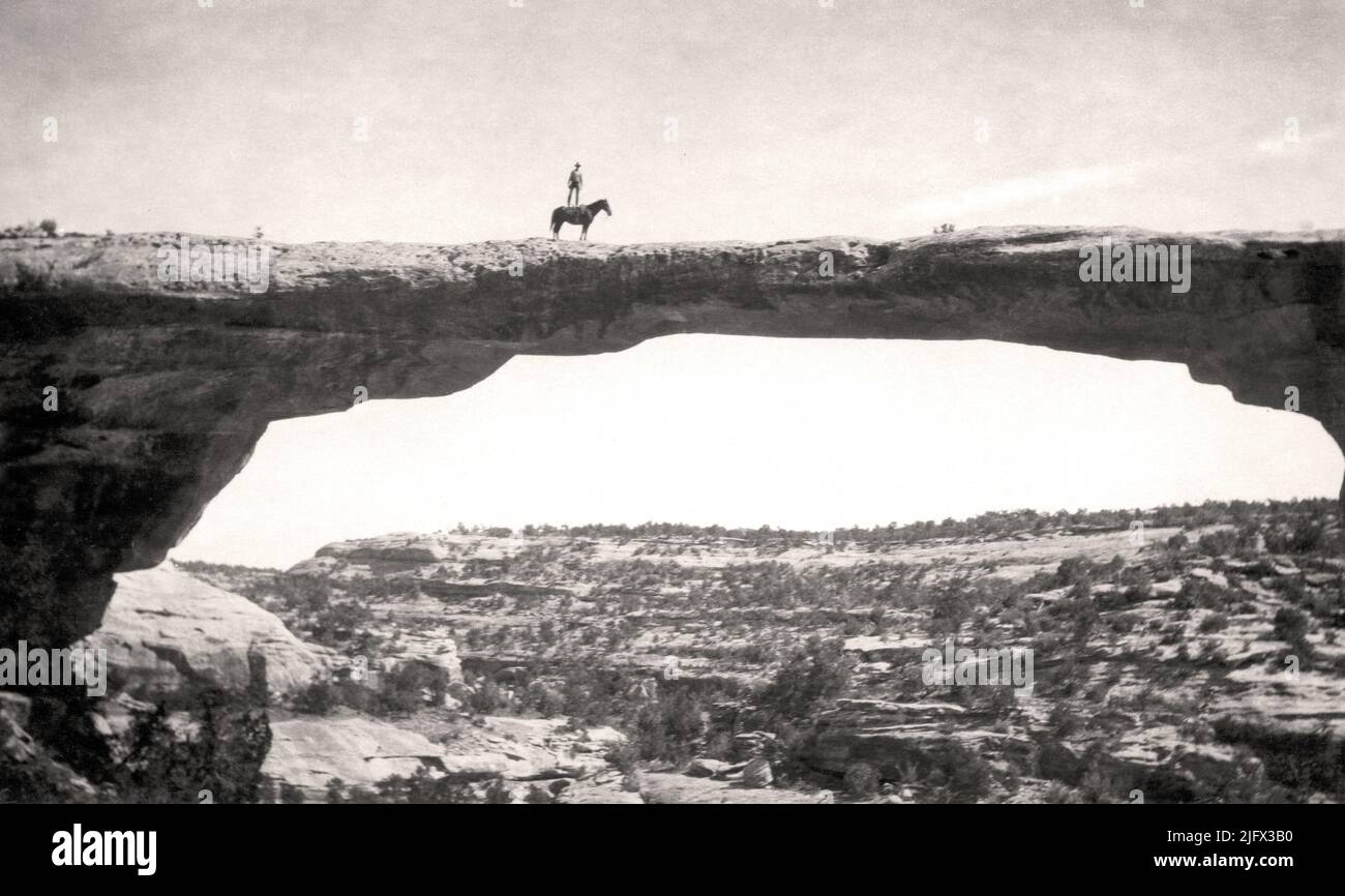 Historisches Bild. Vertrauen. Dan Perkins von der US Geological Survey steht auf seinem Pferd 'Cap' auf der Owachomo Bridge, Natural Bridges National Monument, Utah, USA.circa 1925. Kredit: W.T.Lee / USGS Stockfoto