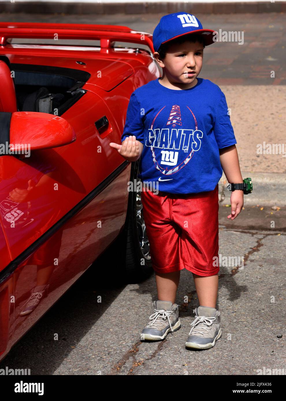 Ein junger Baseballfan der New York Giants besucht eine Autoshow vom 4. Juli in Santa Fe, New Mexico. Stockfoto