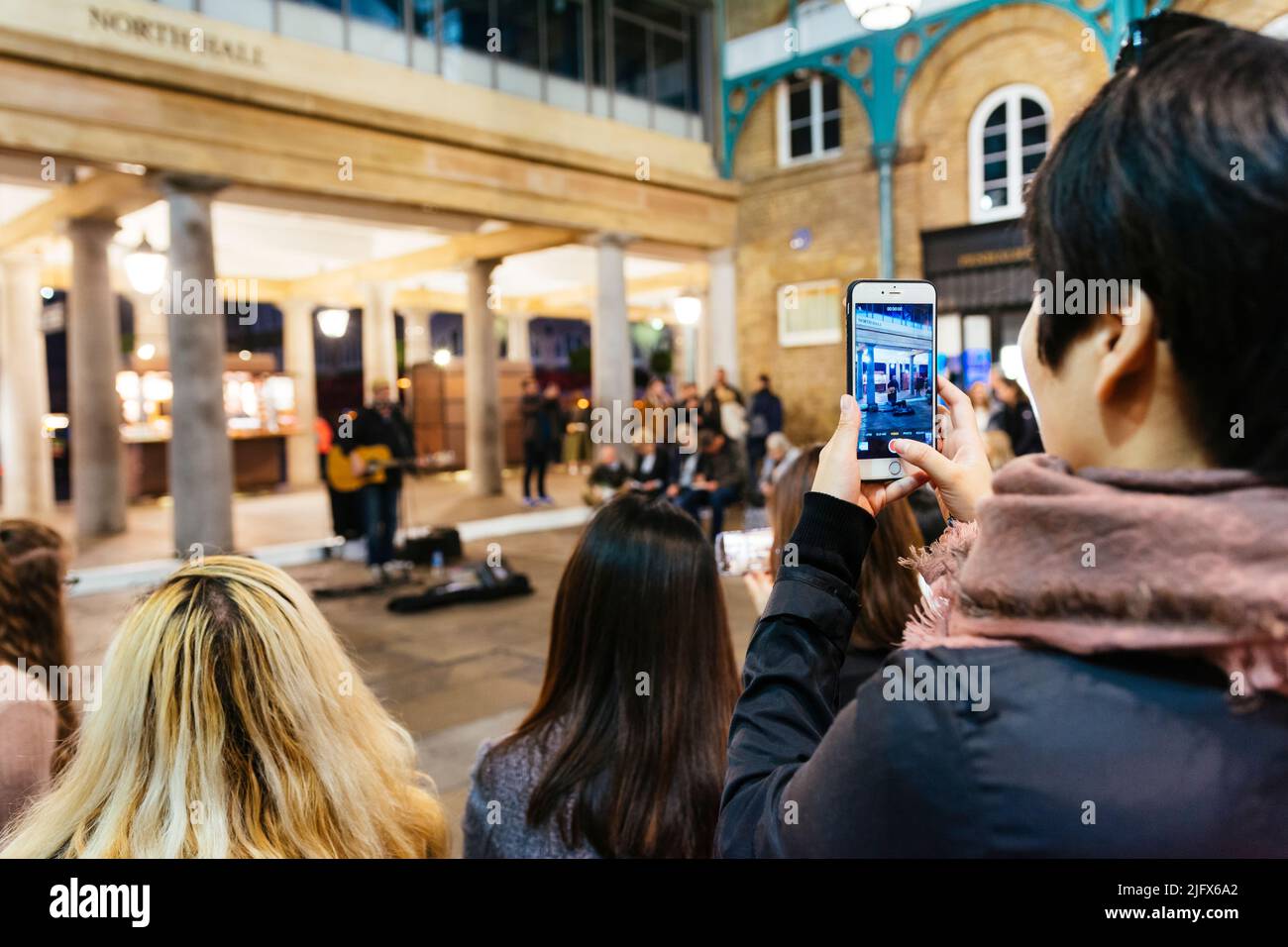 Tourist zeichnet mit seinem Mobiltelefon eine Vorstellung auf. Covent Garden Market. London, Vereinigtes Kindom, Europa Stockfoto