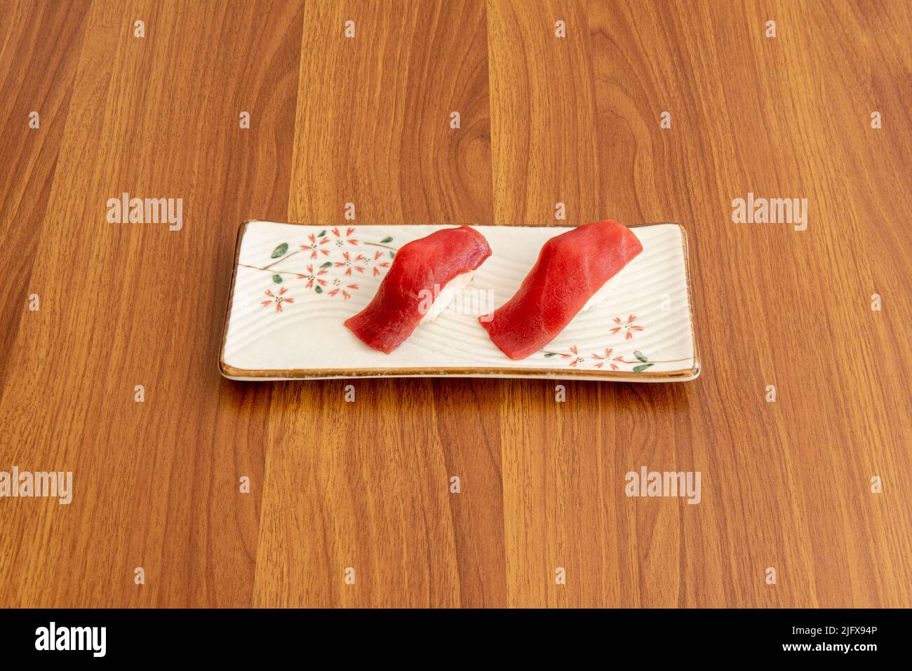 Portion mediterraner roter Thunfisch nigiri mit japanischem Reis in rechteckigem weißem Porzellanteller Stockfoto