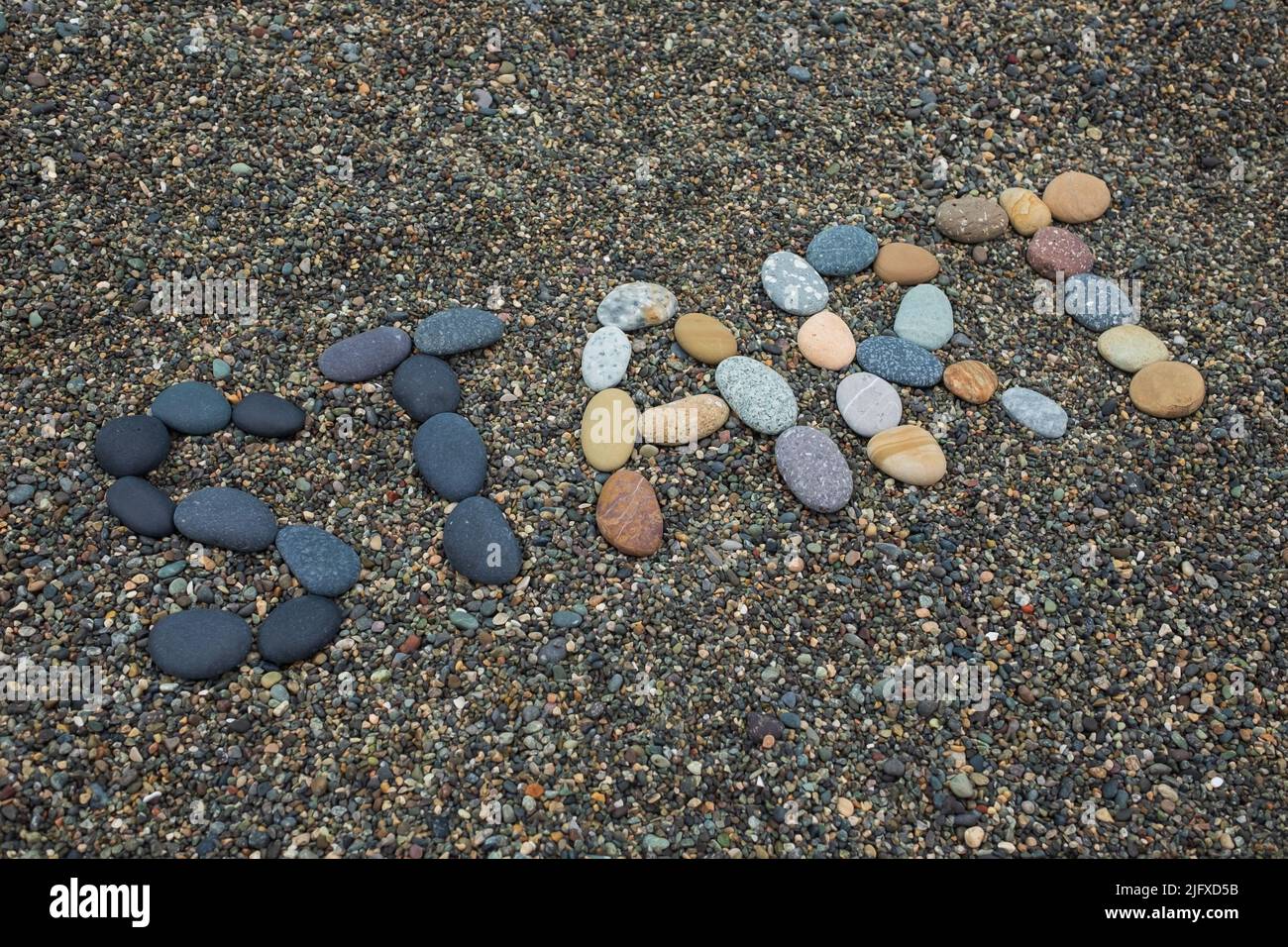 Wortanfang aus Steinen am Sandstrand Stockfoto