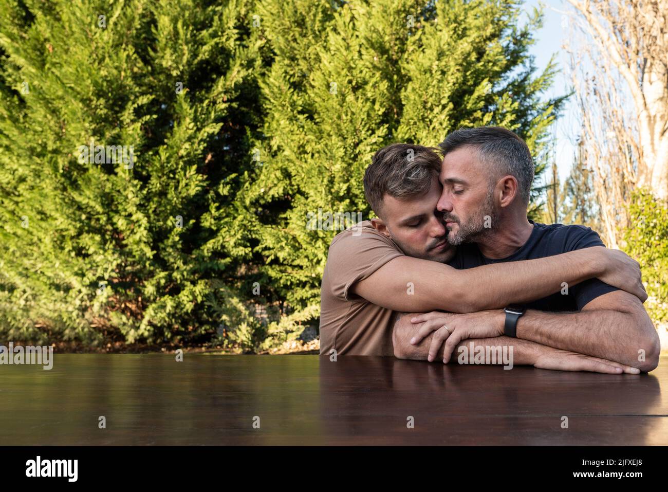 Ein junger Mann umarmte seinen Mann. Beide mit geschlossenen Augen. Copyspace Stockfoto