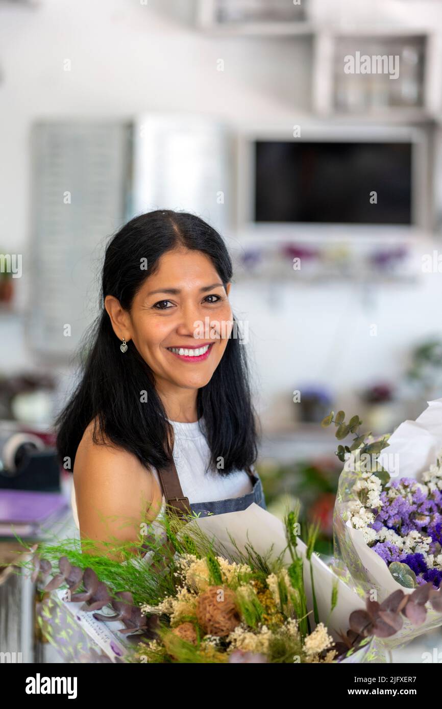 Glückliche Frau in ihrem Blumenladen Stockfoto