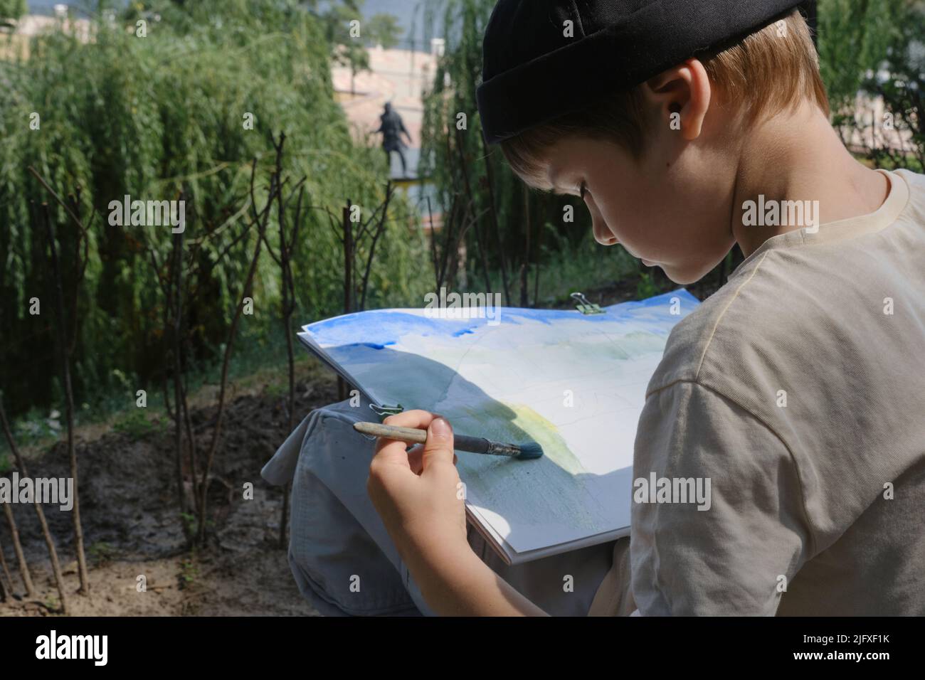 Junge im Schulalter lieben es, in Parks zu malen Stockfoto