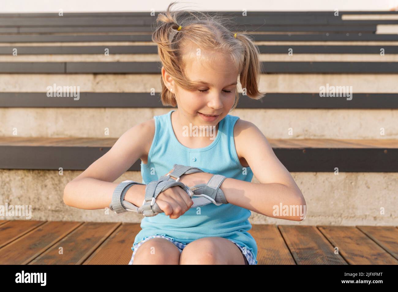 Das Mädchen legt auf Handschutz auf Rollerblade. Stockfoto
