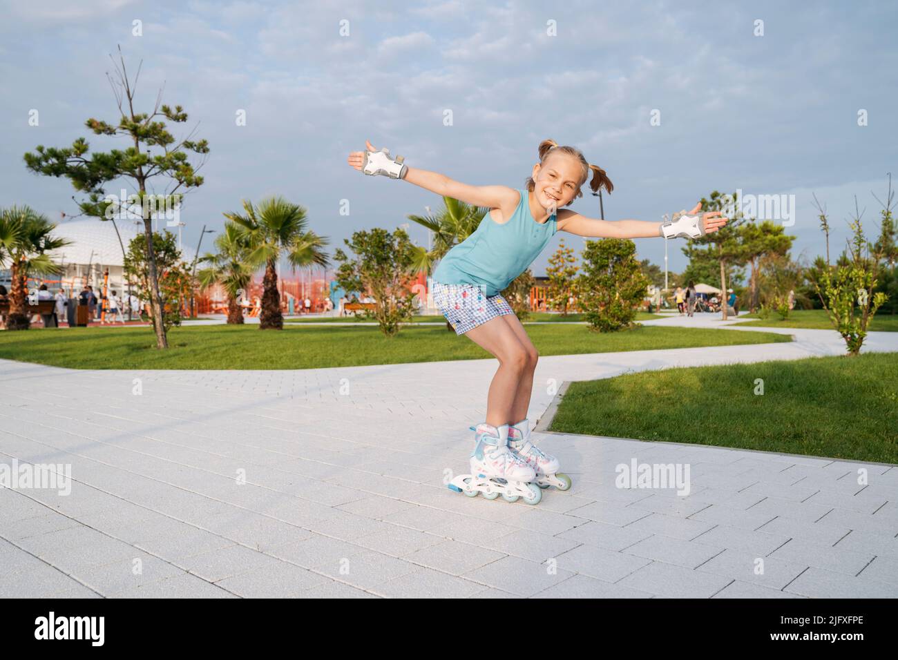 Ein Mädchen ist Rollschuhlaufen in einem Sportpark. Stockfoto