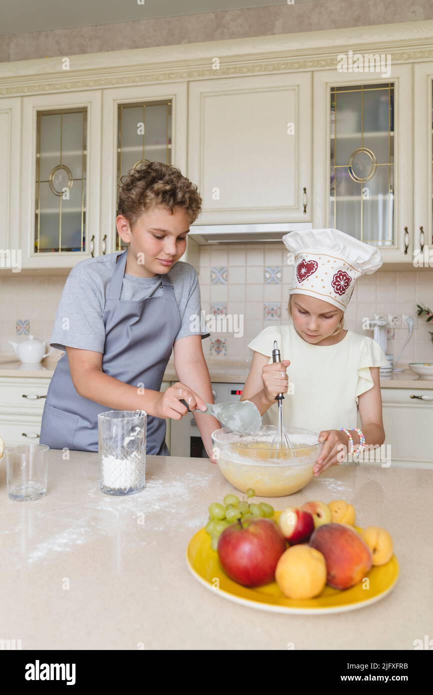 Kinder in der Küche bereiten einen Apfelkuchen zu. Stockfoto