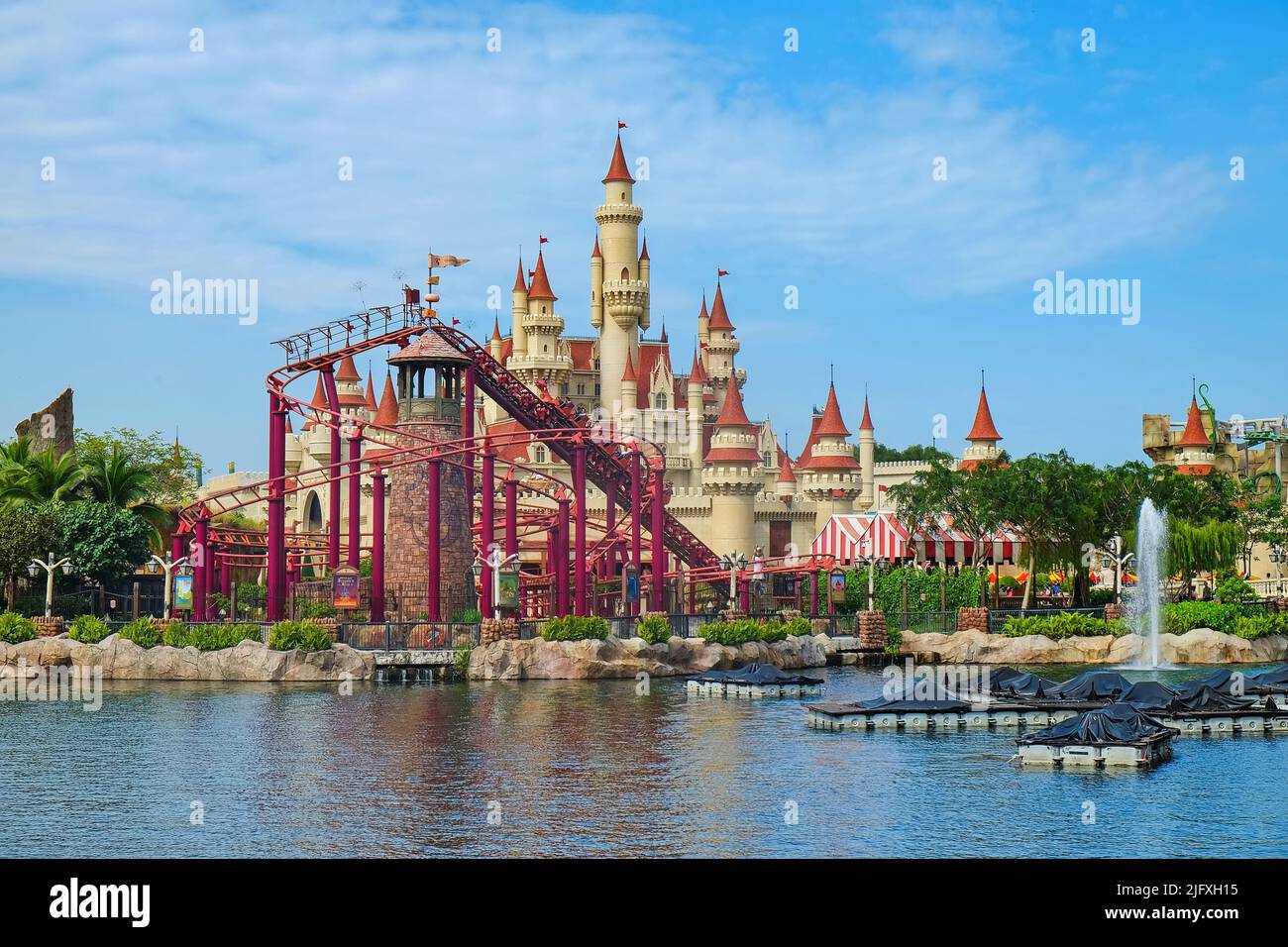Landschaftsansicht des wunderschönen Märchenschlosses mit der Achterbahn in weit entfernter Zone in den Universal Studios Singapore, einem Themenvergnügungspark Stockfoto