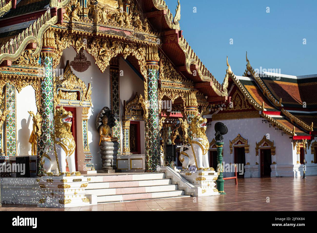 Die exquisiten Muster der thailändischen Kunst schmücken die Betontüren im Wat Phra That Cheng Chum Worawihan. Es ist ein wichtiger heiliger Ort Thailands. Stockfoto