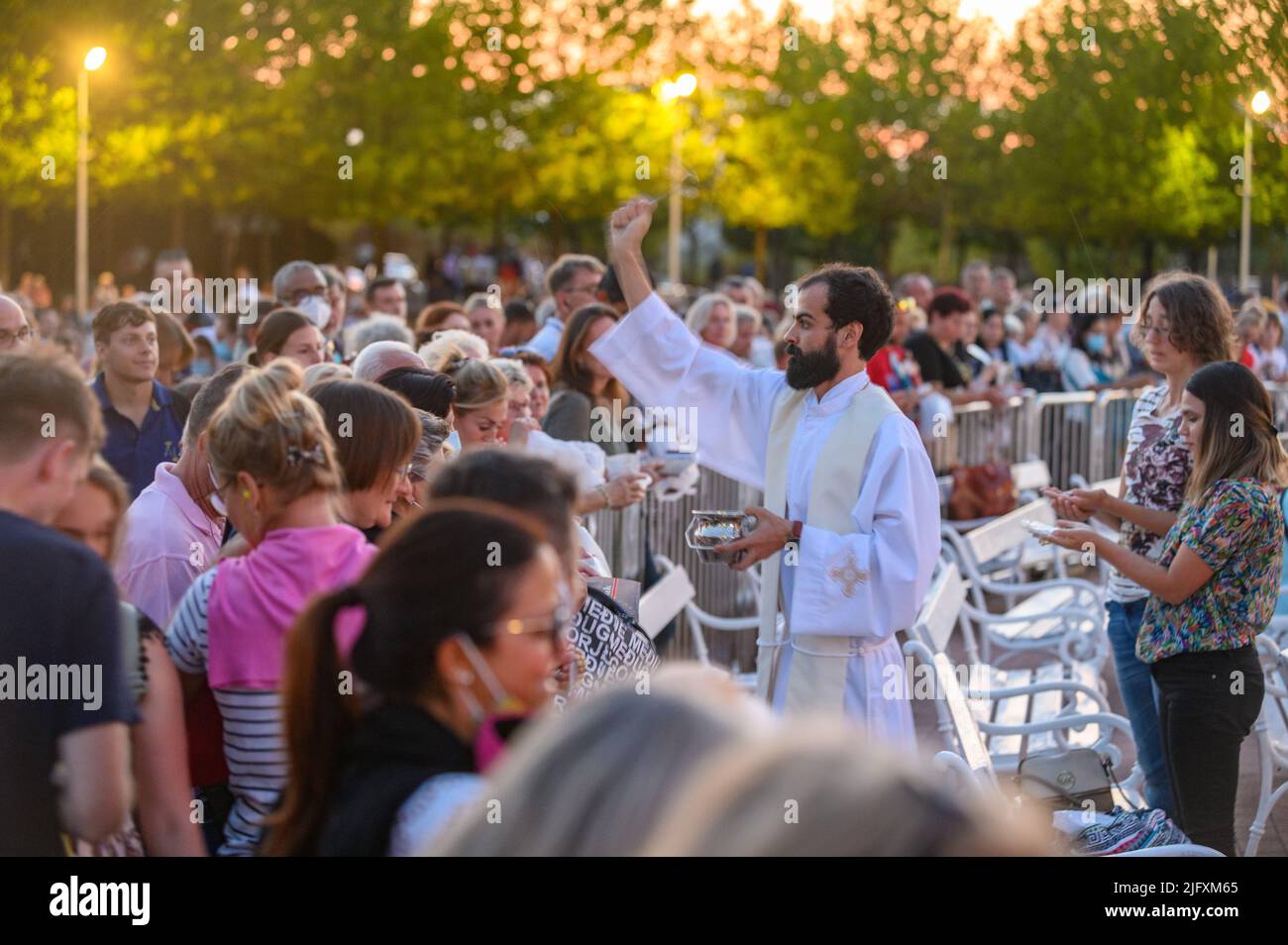 Ein Priester segnet die religiösen Artikel der Gläubigen nach der abendlichen heiligen Messe in Medjugorje am 4. September 2021. Stockfoto