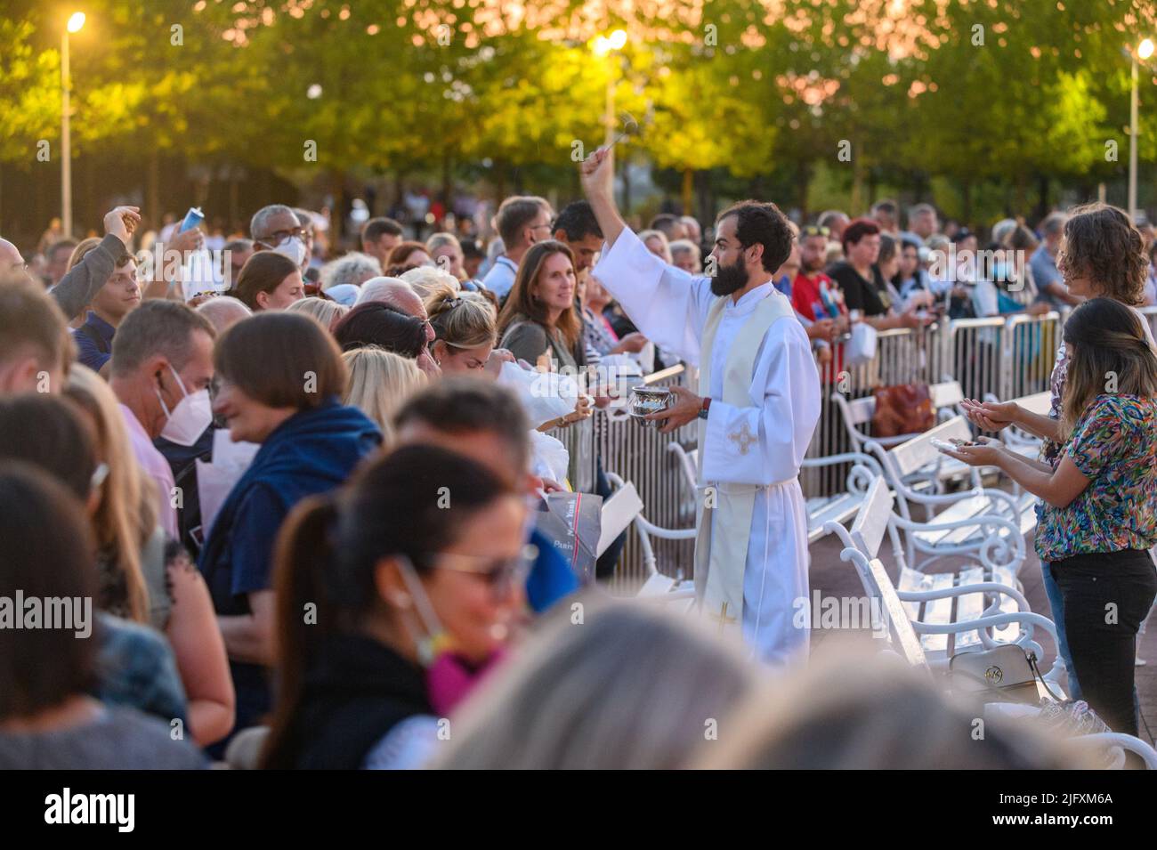 Ein Priester segnet die religiösen Artikel der Gläubigen nach der abendlichen heiligen Messe in Medjugorje am 4. September 2021. Stockfoto