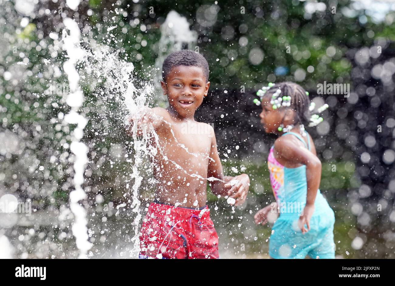 St. Louis, Usa. 05.. Juli 2022. Tae Jones (7) und seine Schwester Riya (4) schlugen die 100-Grad-Hitze, indem sie sich am Dienstag, den 5. Juli 2022, in den Düsensprühen im City Garden in St. Louis kühl hielten. Für die Gegend von St. Louis wurde eine übermäßige Hitzewarnung ausgegeben, da die Temperaturen in der Nähe von 100 Grad steigen und sich für den Rest der Woche wie Temperaturen von 110 Grad anfühlen. Foto von Bill Greenblatt/UPI Credit: UPI/Alamy Live News Stockfoto