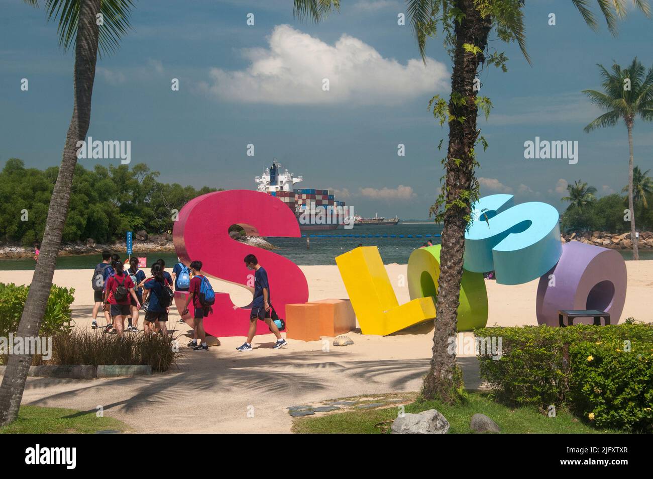 Siloso Beach, Sentosa Island, mit Containerschifffahrt in der Nähe, Singapur Stockfoto