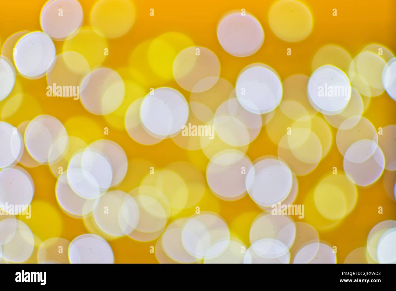 Hintergrundbild mit gelben und weißen Bokeh-Lichtern. Stockfoto