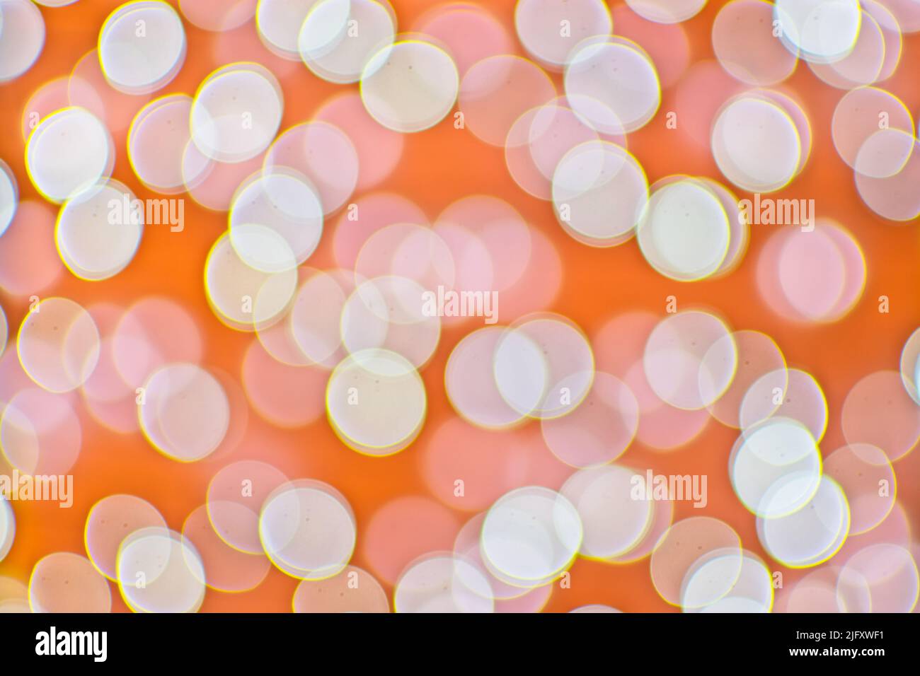 Hintergrundbild mit orangefarbenen und weißen Bokeh-Lichtern. Stockfoto