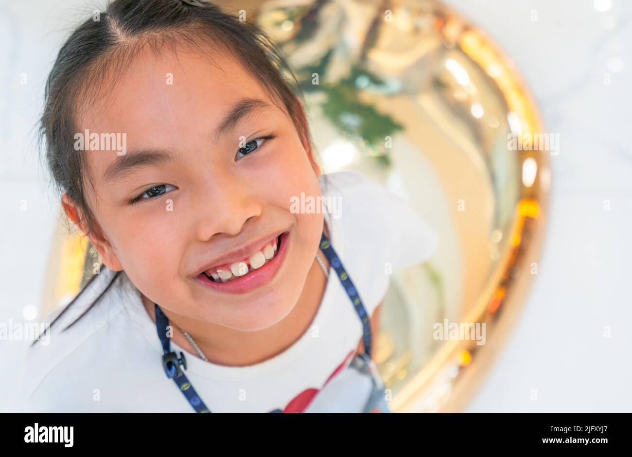 Close-up niedlich asiatische kleine Mädchen Gesicht mit einem Lächeln und schönen Augen Blick auf die Kamera, Innenaufnahmen, gesundes Kind 7-8 Jahre alt, Foto Stockfoto