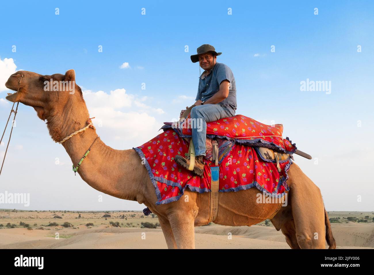 Thar Wüste,Rajasthan,Indien-15. October 2019 : Indischer männlicher Tourist, der im Desrt ein Kamel reitet, Kamele, Camelus dromedarius, in Sanddünen. Stockfoto
