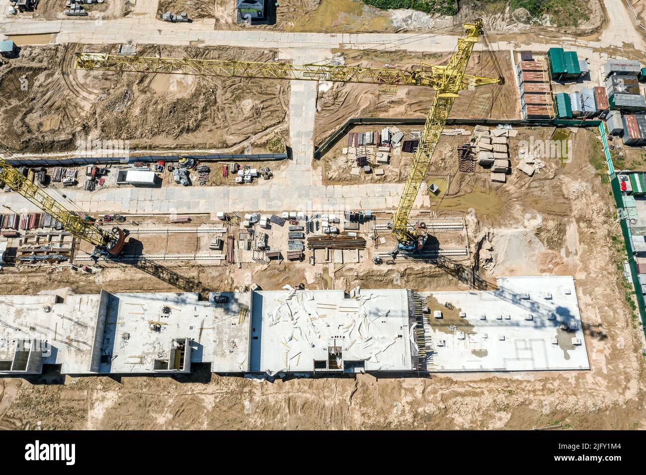 Luftaufnahme der Baustelle mit hohem gelben Kran. Bau eines Fundaments des Gebäudes. Stockfoto