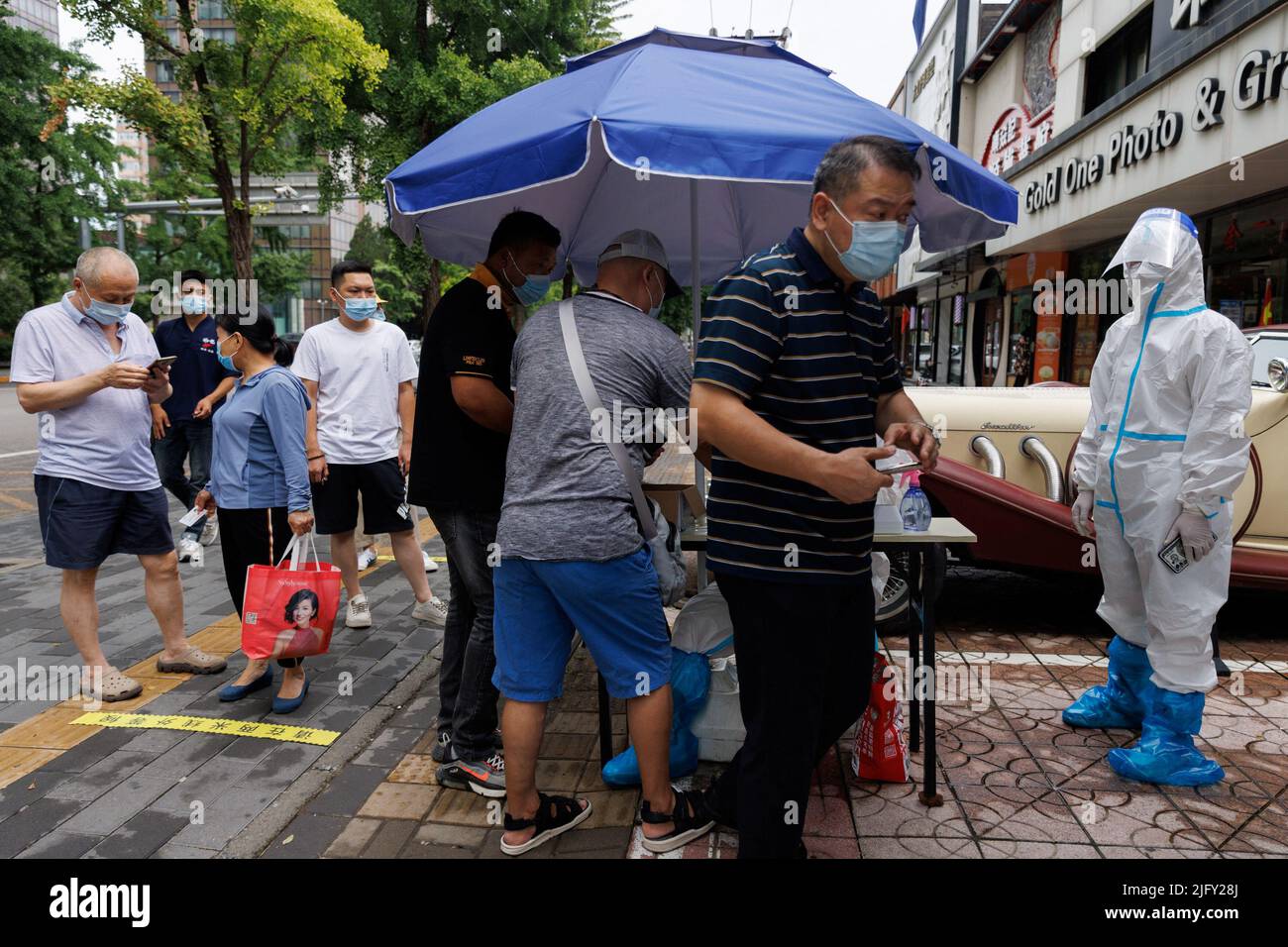 Nach einem Ausbruch der Coronavirus-Krankheit (COVID-19) stehen Menschen in Peking, China, am 6. Juli 2022, an einer Nukleinsäureteststation an. REUTERS/Thomas Peter Stockfoto