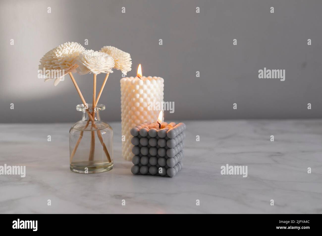 Home Duft Duft Diffusor und brennende Kerzen auf Marmor Hintergrund. Innenraumelemente. Nach Hause duftendes Aroma. Wellness Stockfoto